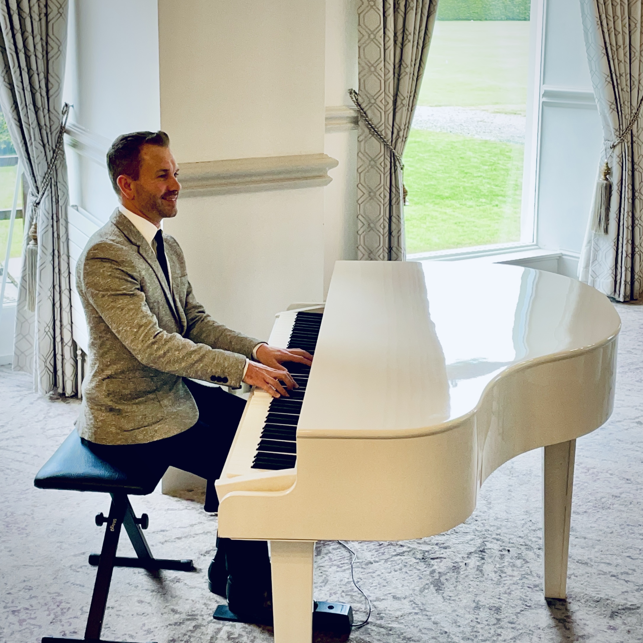 Inn on the Lake wedding pianist Craig Smith plays a white baby grand piano for a wedding ceremony