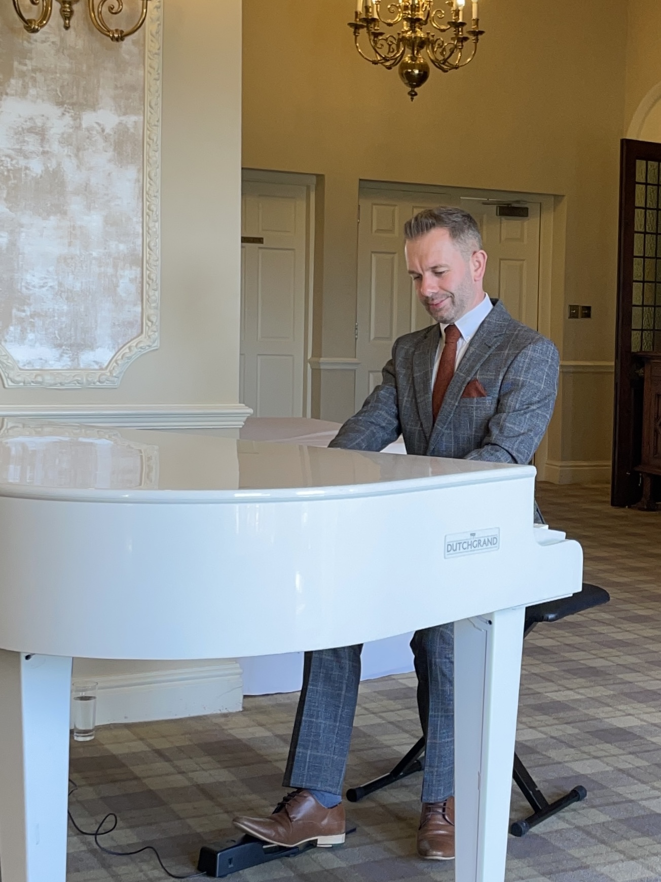 Craig Smith plays his white baby grand piano for a Merewood Country House wedding breakfast